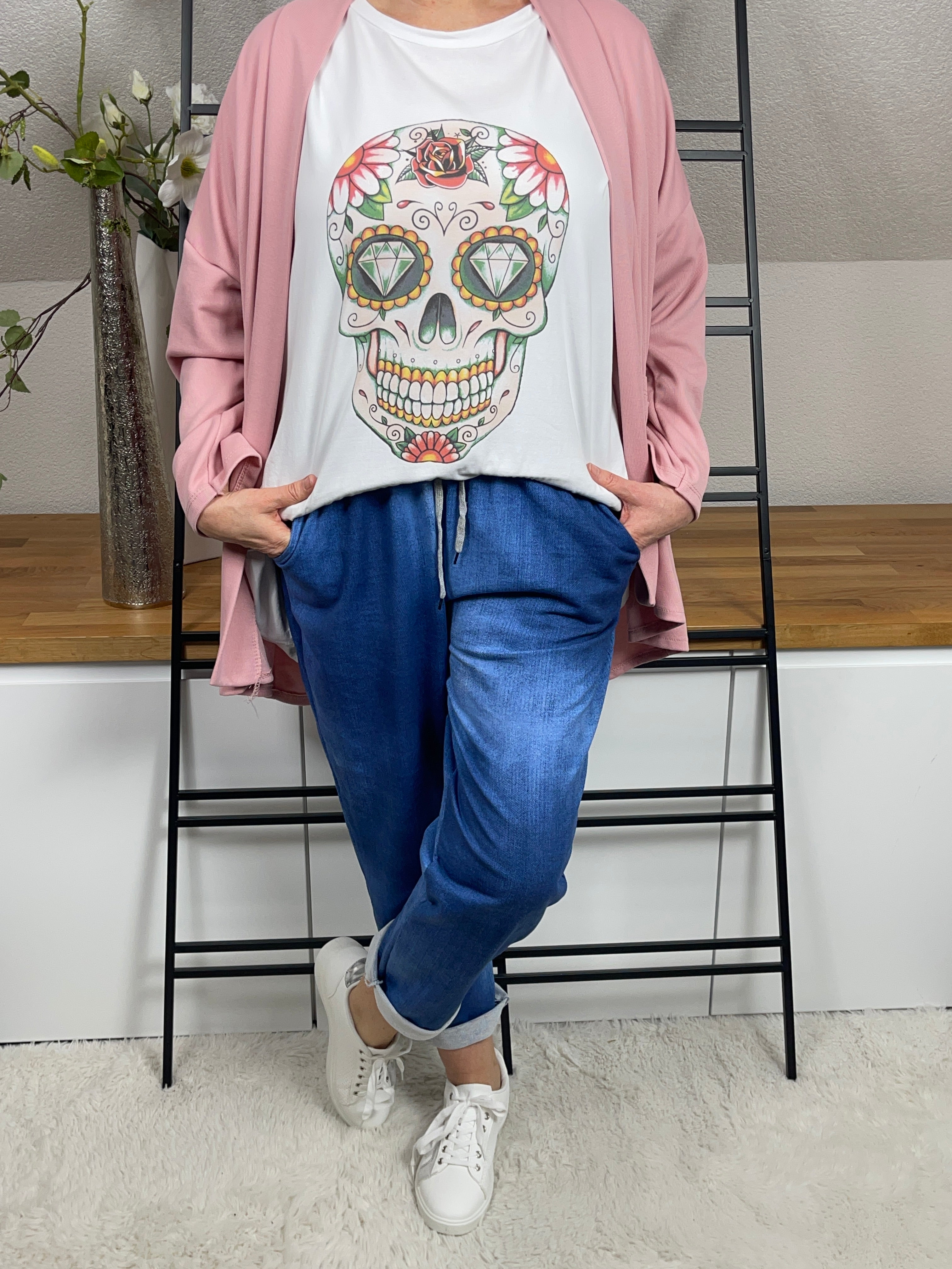Oversized T - Shirt in Weiß - Bunt mit Totenkopf - Design, kombiniert mit Jogpant, Sneakern und einem lässigen Cardigan. Frontansicht, bequemer und stylischer Look.